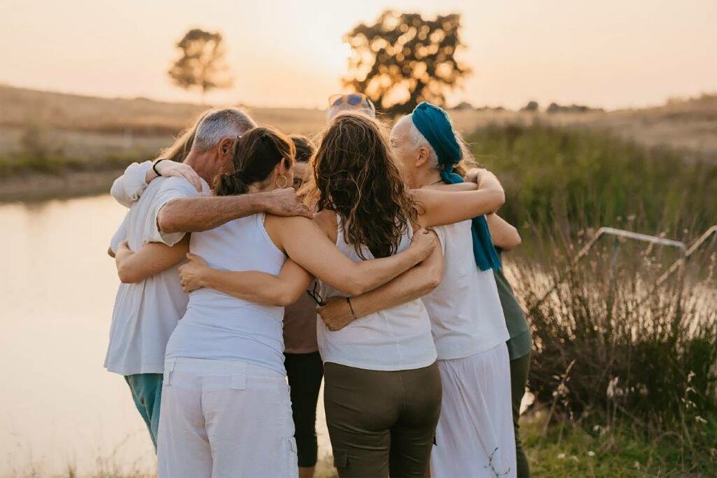 A family shares a group hug during a journey with Behold Retreats