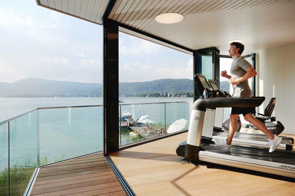 A guests on a treadmill with views over the Lake Wörthersee, Austria