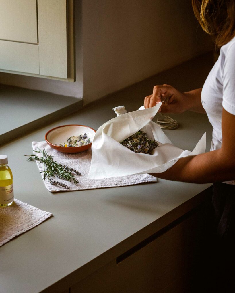 A staff members lays out dried lavender to make an essential oil