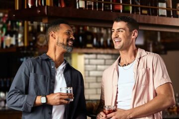 Two gay men enjoy bourbon at Bourbon & Belonging