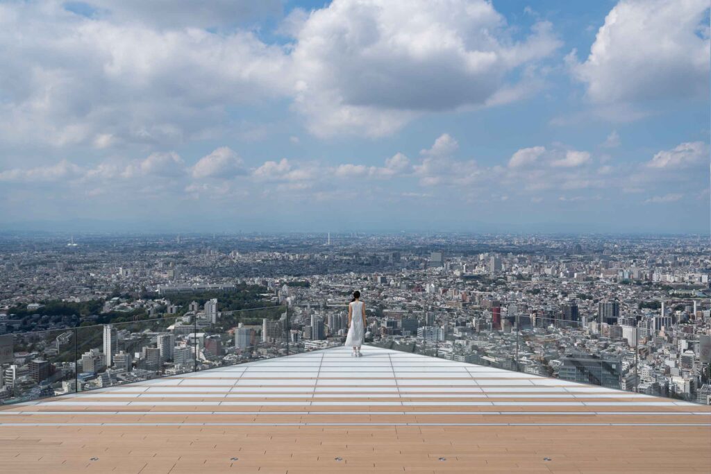 Woman standing on edge at Shibuya Sky