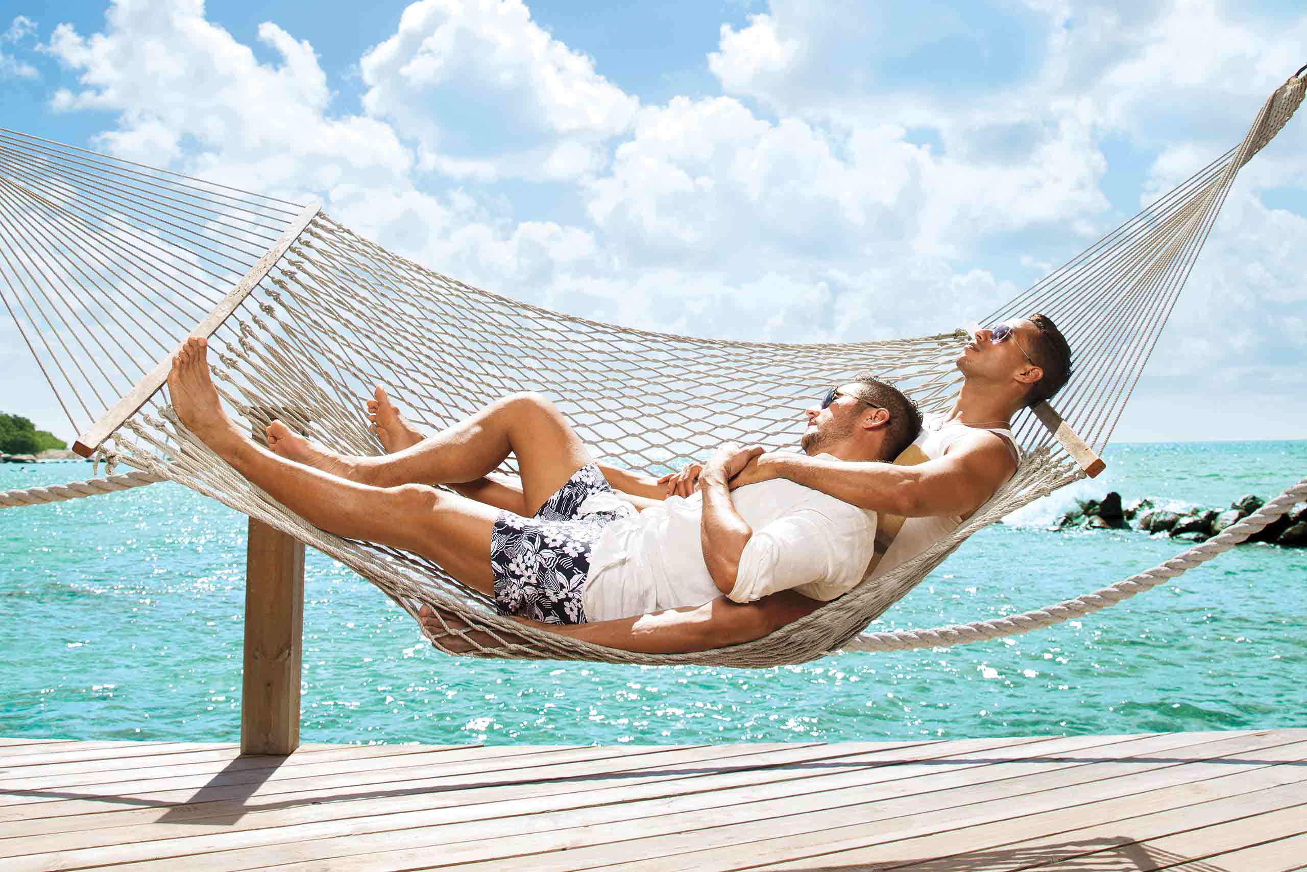 Two men in hammock by the sea in Aruba