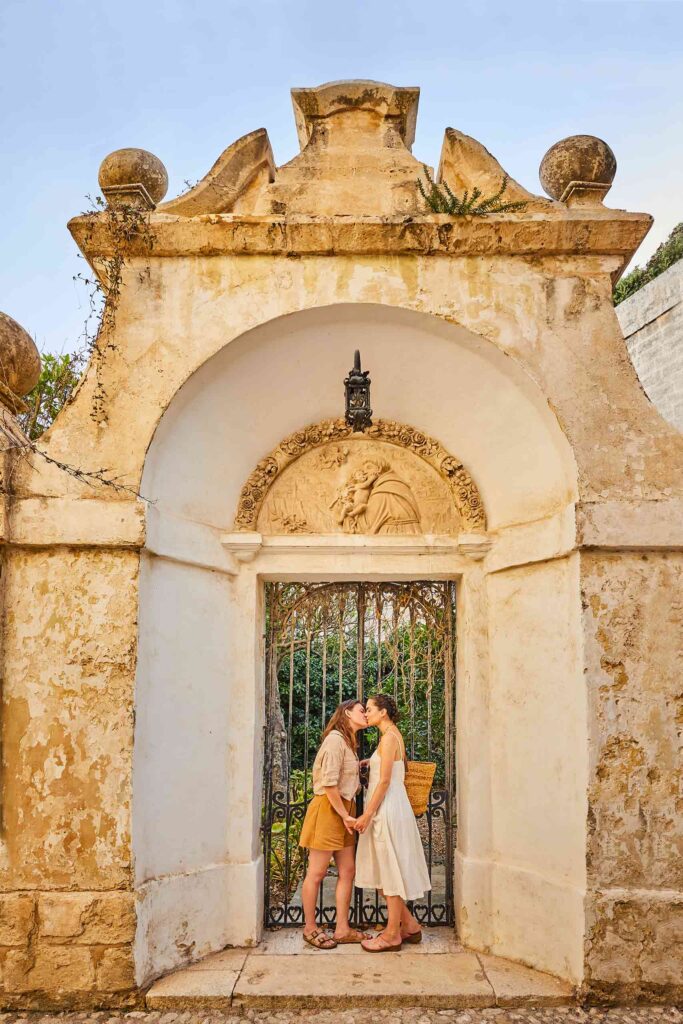 Lesbian couple kissing in an old gateway in Malta