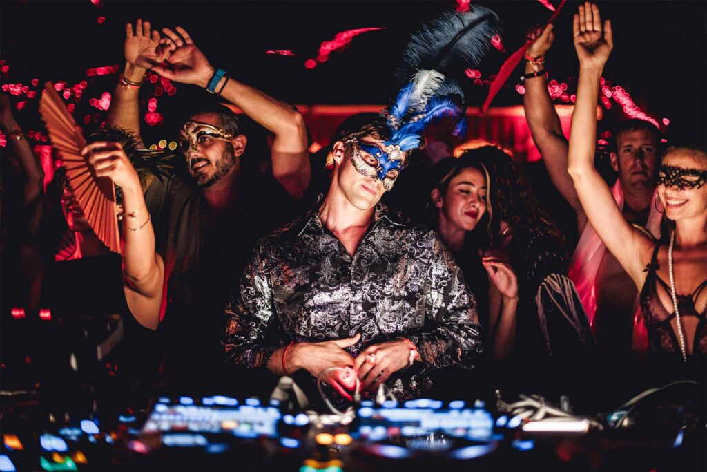 Festivalgoers gathered around a masked DJ.