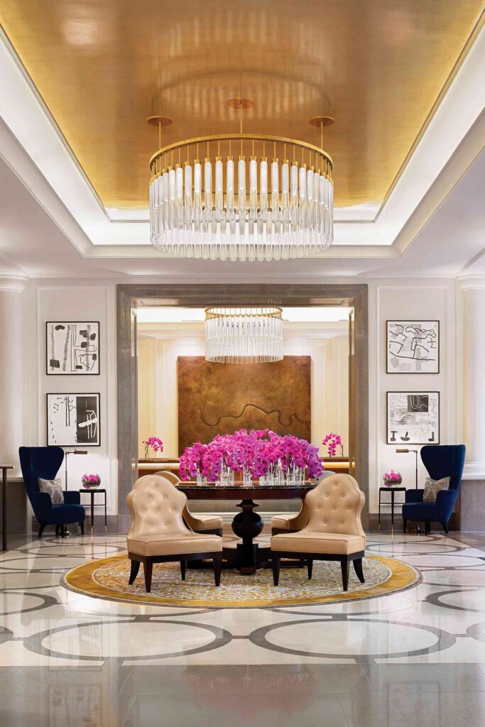 Lobby of Corinthia London with chandelier and fresh flowers