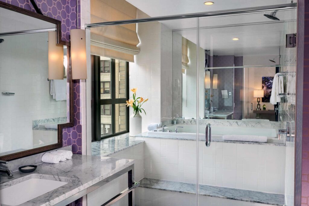 A bathroom with a mirrored wall and a jet tub