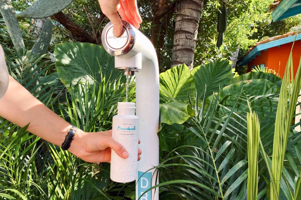 A water refill station surrounded by tropical plants